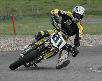 a motorcyclist leaning into a corner to counteract the body force a motorcyclist leaning into a corner to counteract the body force
