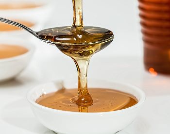 viscous flow of honey from spoon